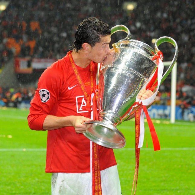 Cristiano Ronaldo besando el trofeo de Champions League con jersey retro Manchester United 2008 manga larga.