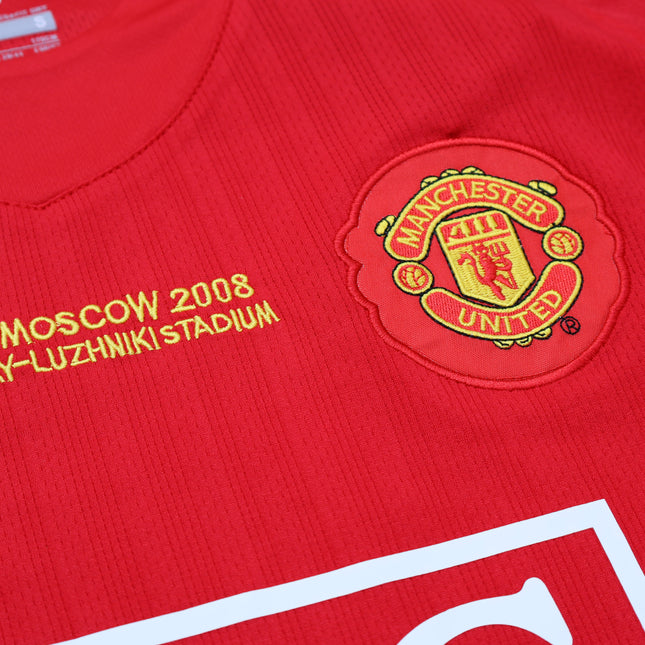 Primer plano del escudo bordado y detalle Final Moscow 2008 en jersey retro Manchester United 2008 rojo.