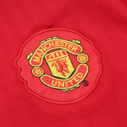 Primer plano del escudo bordado del Manchester United en el jersey retro 2008 de Cristiano Ronaldo, color rojo vivo.